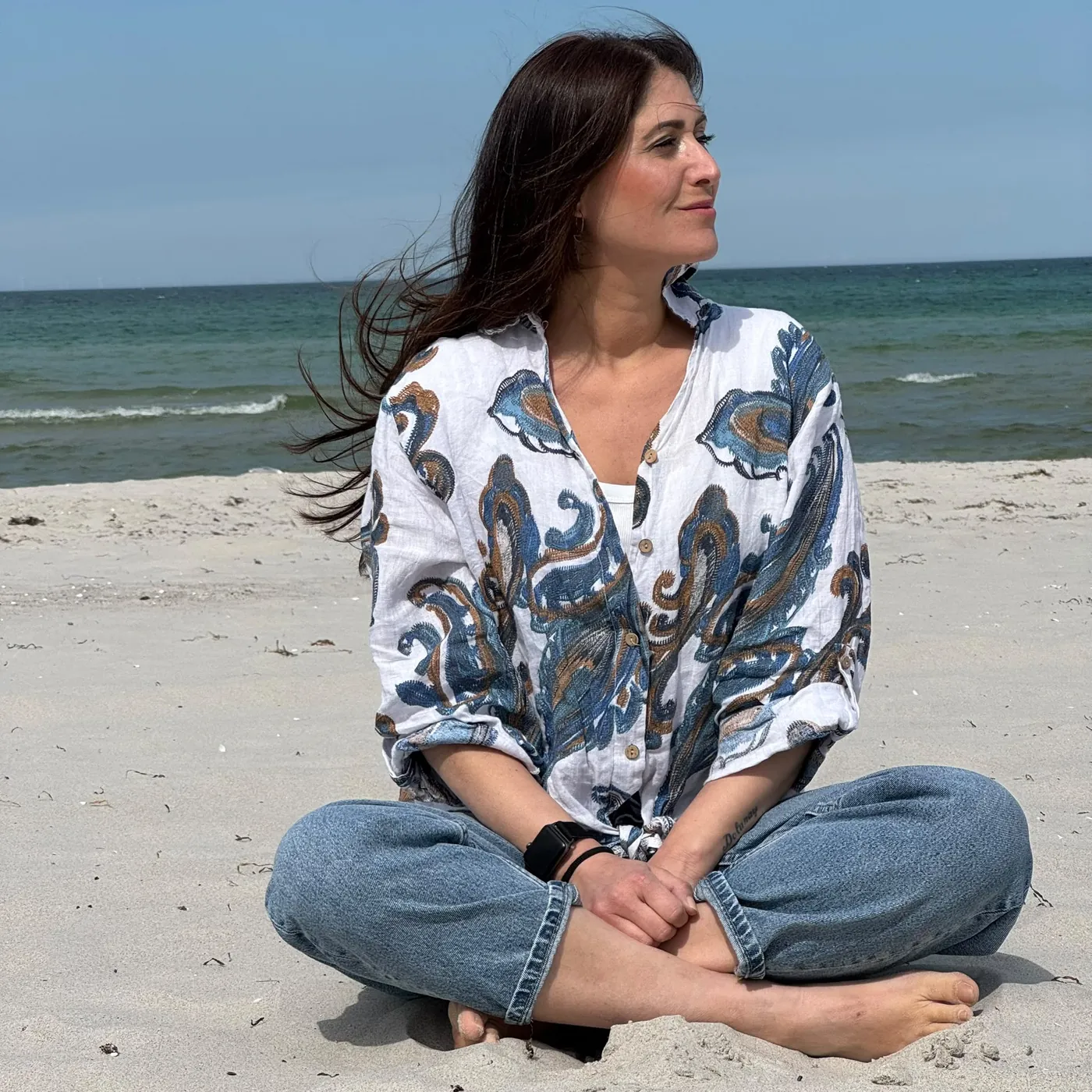 Porträt am Strand, im Gegenlicht, die Hände vor dem Gesicht